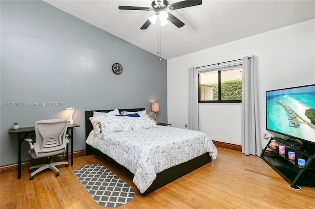 bedroom with lofted ceiling, ceiling fan, light wood-type flooring, and baseboards