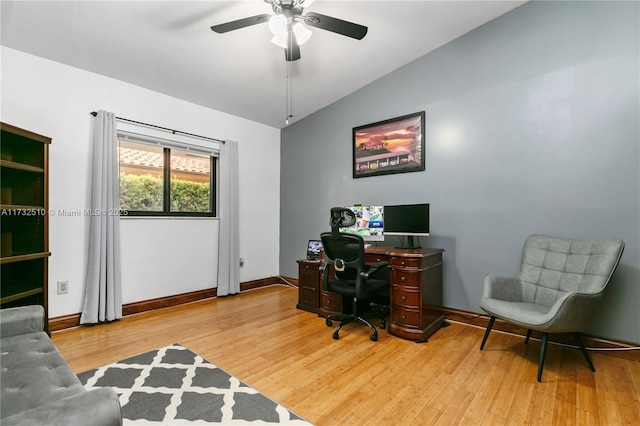 office featuring baseboards, a ceiling fan, vaulted ceiling, and wood finished floors