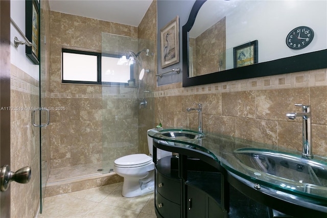 full bathroom featuring toilet, tile patterned floors, vanity, a shower stall, and tile walls