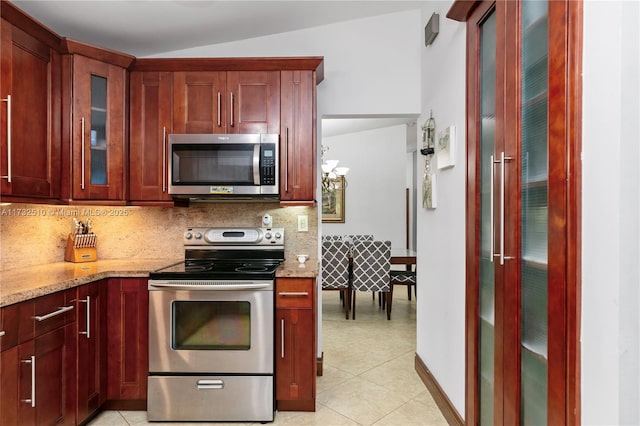 kitchen featuring light stone countertops, tasteful backsplash, stainless steel appliances, and dark brown cabinets