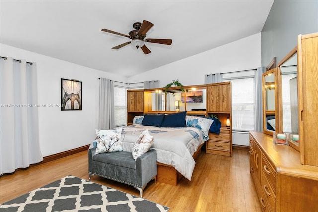 bedroom with vaulted ceiling, multiple windows, and light wood-type flooring