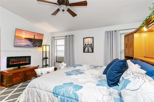 bedroom with lofted ceiling, ceiling fan, cooling unit, and a glass covered fireplace