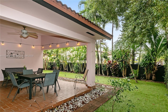 view of patio featuring outdoor dining area, a fenced backyard, and a ceiling fan