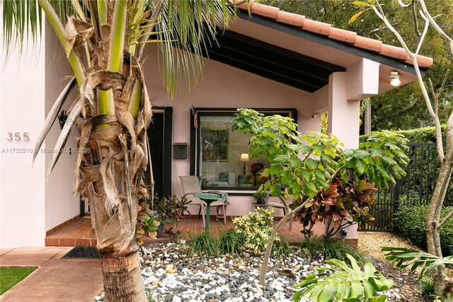 doorway to property with fence and stucco siding