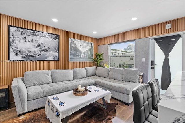 living room featuring hardwood / wood-style flooring and wooden walls