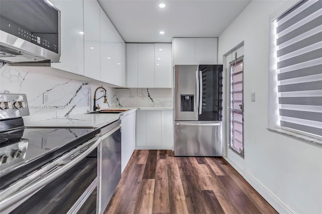 kitchen featuring a sink, white cabinets, appliances with stainless steel finishes, dark wood-style floors, and modern cabinets