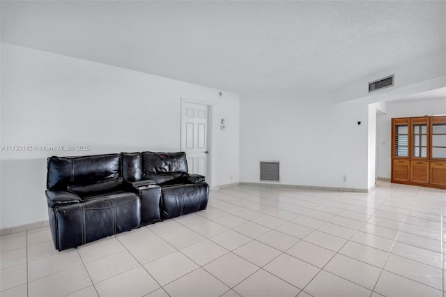 living room with light tile patterned floors, visible vents, and baseboards