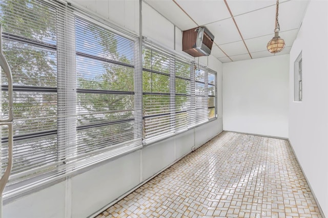 unfurnished sunroom with a drop ceiling