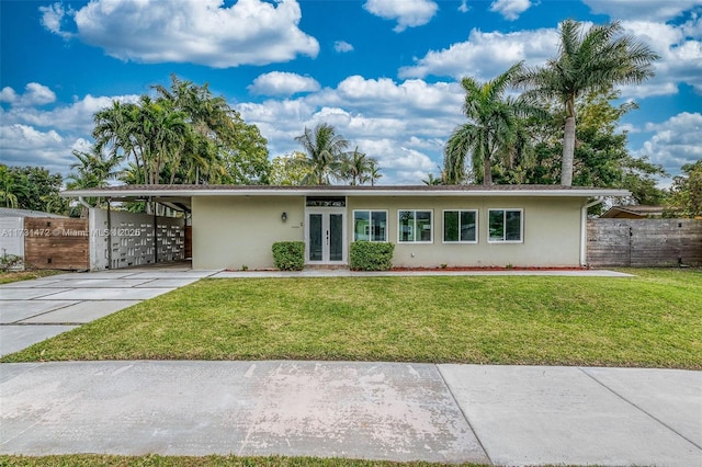 single story home with a carport, a front lawn, and french doors