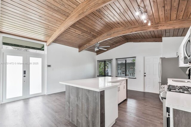 kitchen with tasteful backsplash, wood ceiling, a center island, appliances with stainless steel finishes, and white cabinets