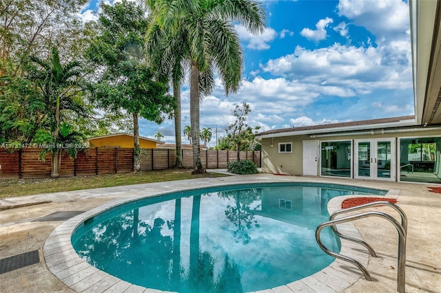 view of swimming pool with a patio area and french doors