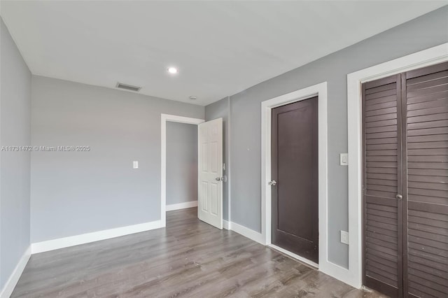 unfurnished bedroom featuring a closet and light wood-type flooring