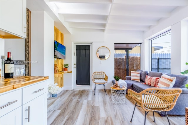 interior space with beamed ceiling and light hardwood / wood-style flooring