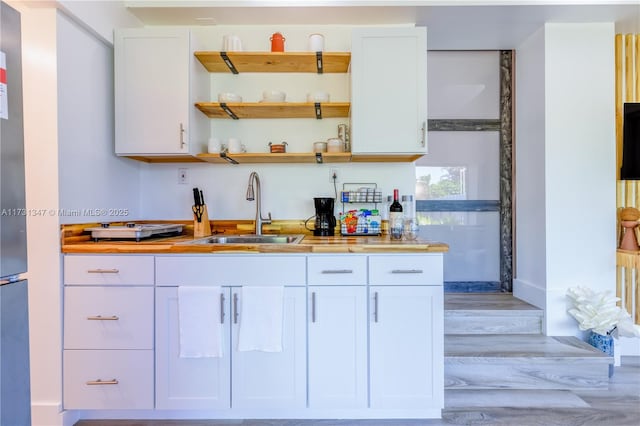 kitchen featuring sink, light hardwood / wood-style flooring, and white cabinets