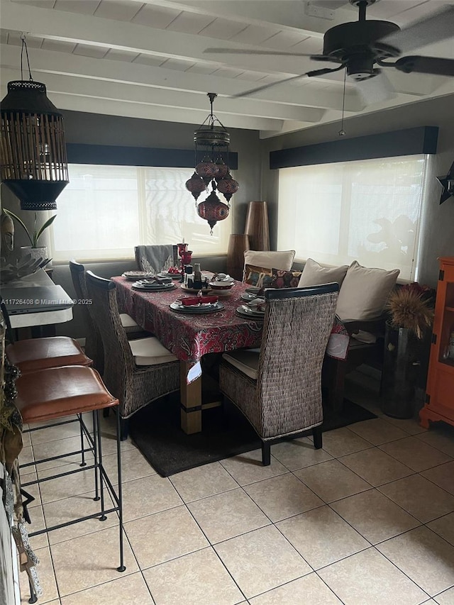 dining area featuring beamed ceiling, ceiling fan, and light tile patterned flooring