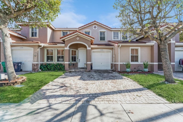 mediterranean / spanish house with a garage and a front yard