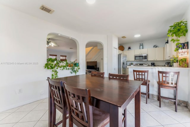 dining space with ceiling fan and light tile patterned flooring