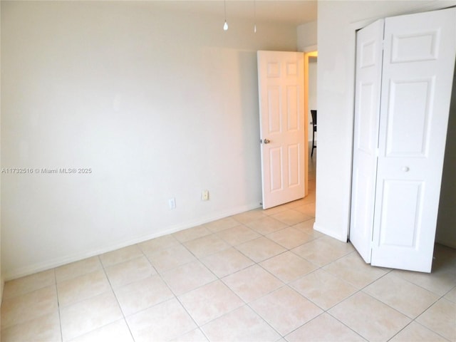 unfurnished bedroom with light tile patterned floors and a closet