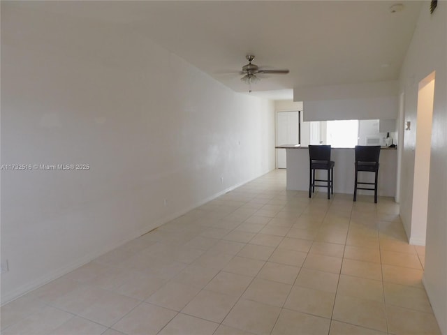 tiled spare room with ceiling fan