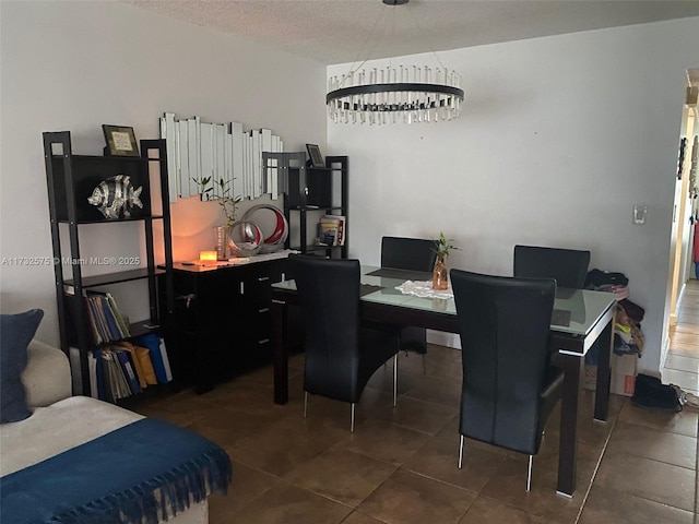 dining room with dark tile patterned floors and a textured ceiling