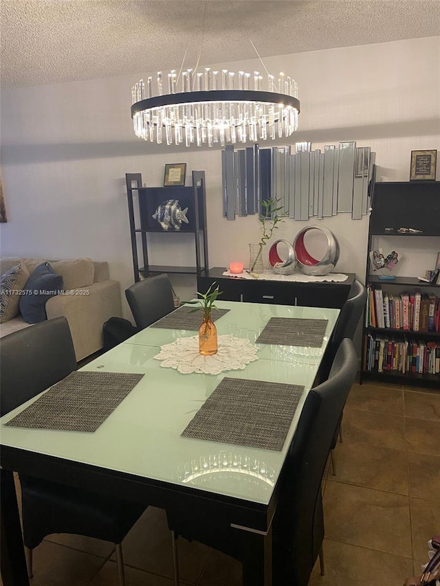 tiled dining area featuring a notable chandelier and a textured ceiling