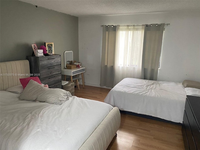 bedroom with hardwood / wood-style flooring and a textured ceiling