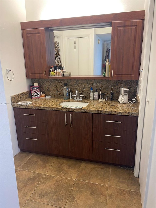 kitchen with sink, decorative backsplash, and stone counters