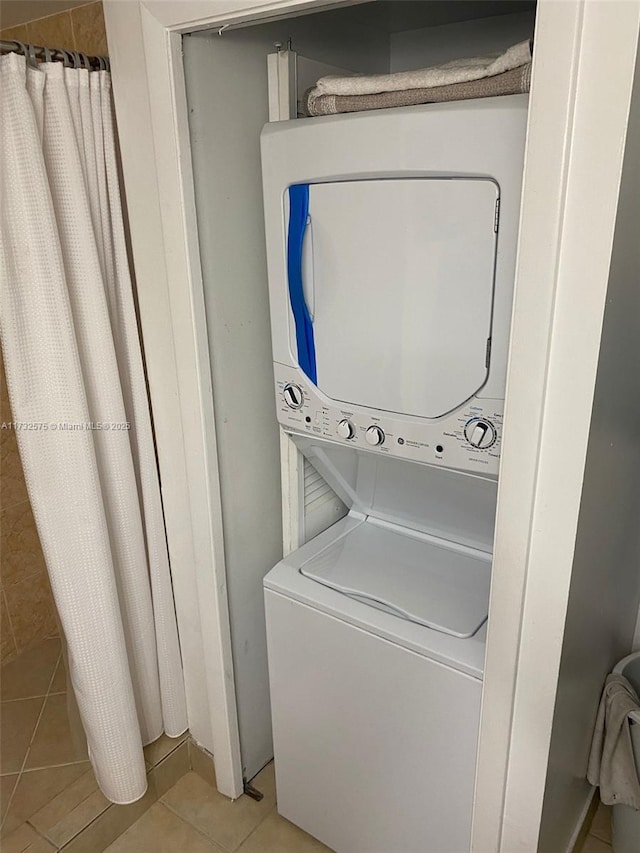 washroom featuring light tile patterned floors and stacked washer / dryer