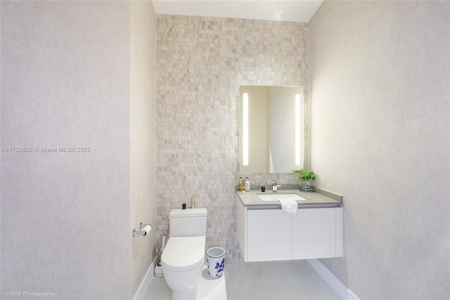 bathroom with vanity, toilet, and tile walls