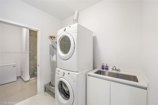 clothes washing area featuring electric water heater, sink, stacked washer / drying machine, and light tile patterned floors