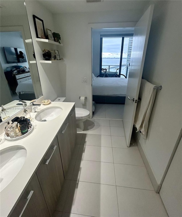 bathroom featuring vanity, tile patterned flooring, and toilet