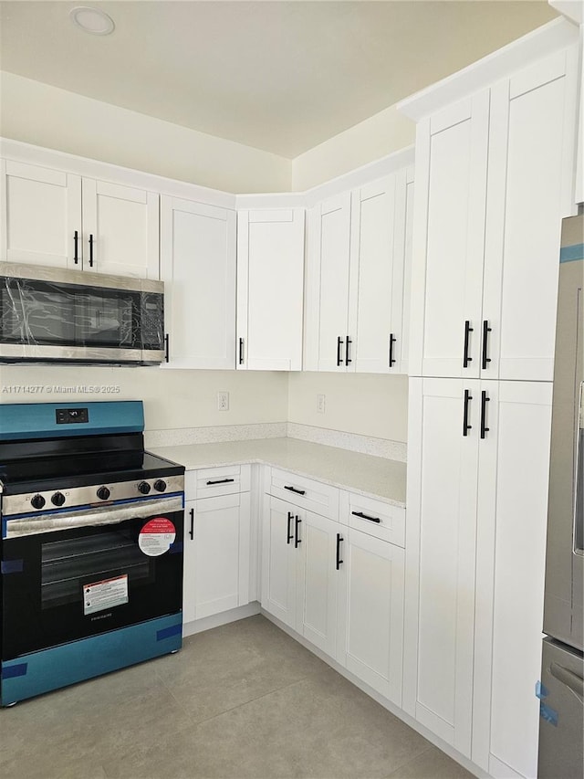 kitchen with white cabinetry and appliances with stainless steel finishes