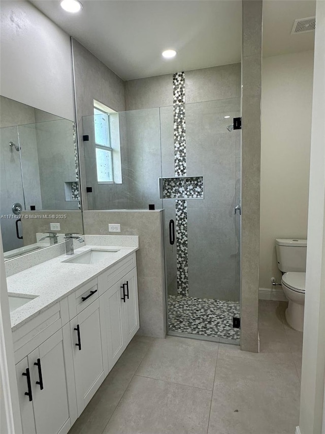 bathroom featuring vanity, tile patterned floors, toilet, and walk in shower