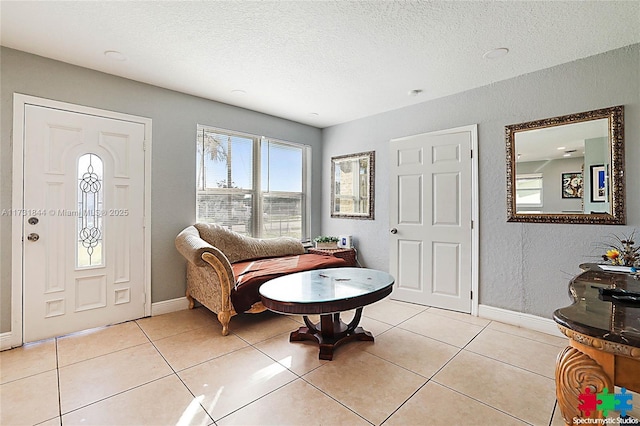 foyer with light tile patterned flooring and a textured ceiling