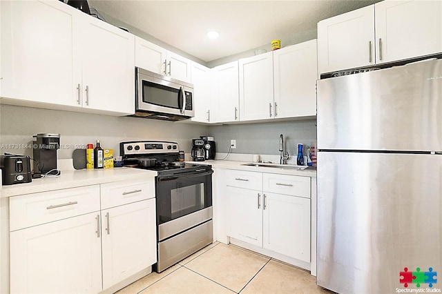 kitchen featuring white cabinetry, appliances with stainless steel finishes, sink, and light tile patterned floors