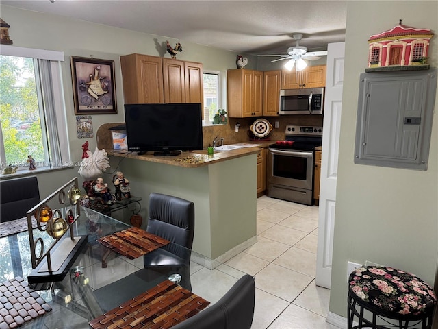 kitchen with light tile patterned floors, plenty of natural light, stainless steel appliances, and electric panel