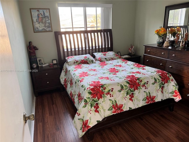 bedroom with dark hardwood / wood-style floors