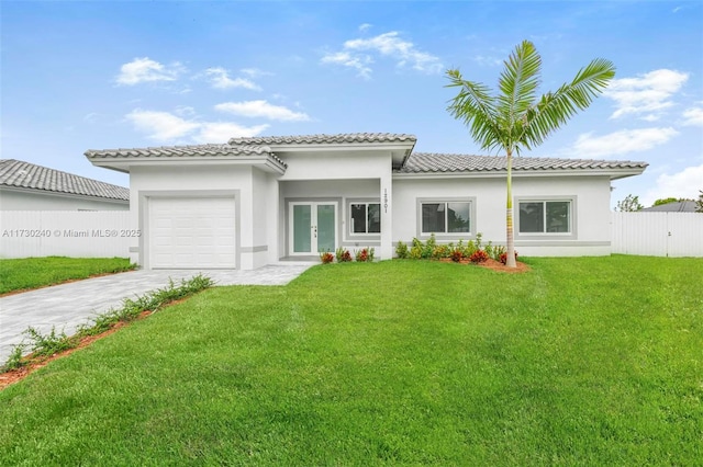 exterior space with a garage, a lawn, and french doors