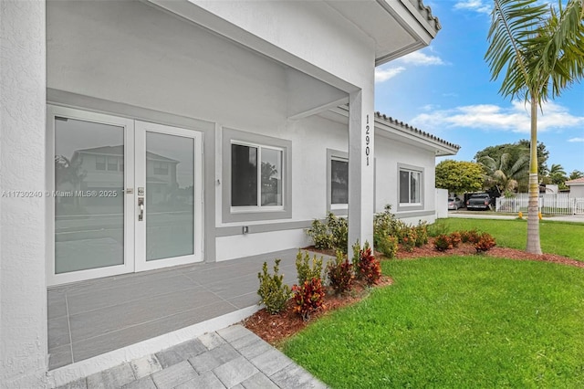 view of side of property featuring a yard and french doors