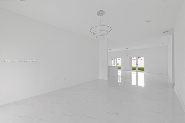 empty room featuring an inviting chandelier and french doors