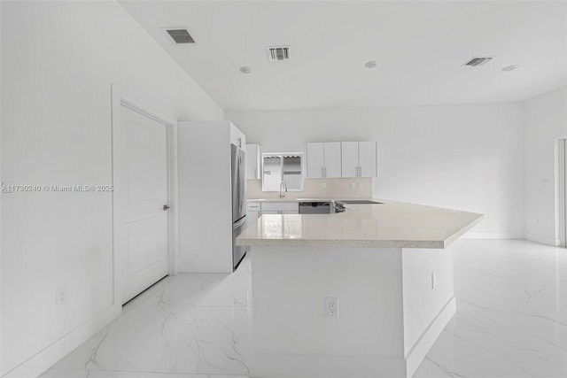 kitchen featuring stainless steel appliances, white cabinetry, and a center island