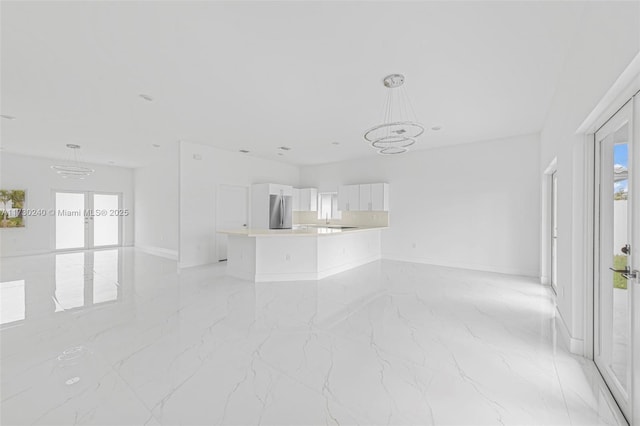 unfurnished living room featuring a chandelier