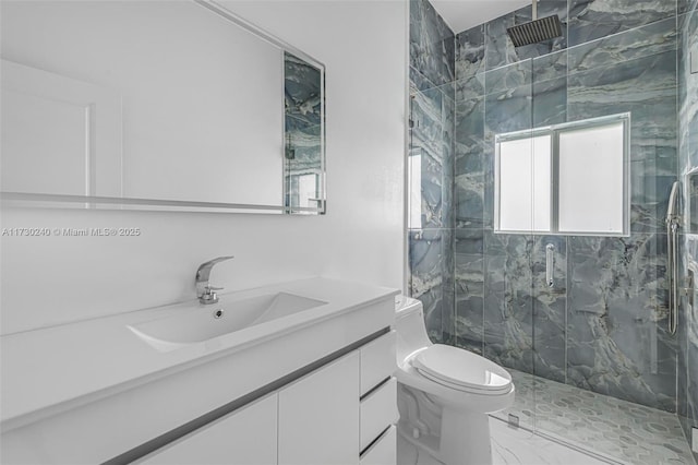 bathroom featuring vanity, a shower with door, and toilet