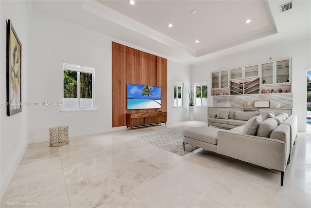 living room featuring a tray ceiling and ornamental molding