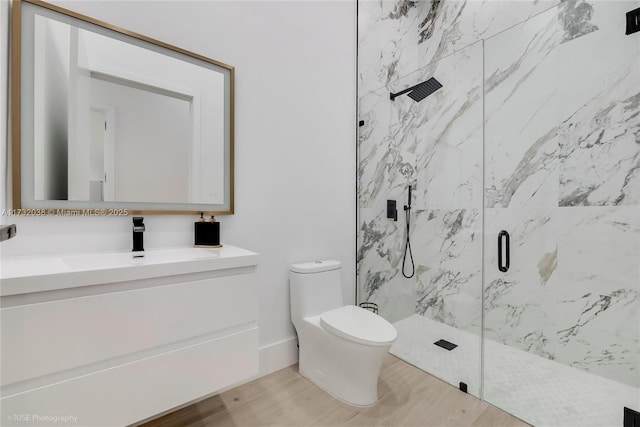 bathroom featuring vanity, hardwood / wood-style floors, a shower with door, and toilet