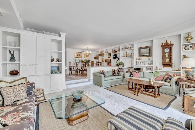 living room featuring built in shelves, ornamental molding, and a notable chandelier