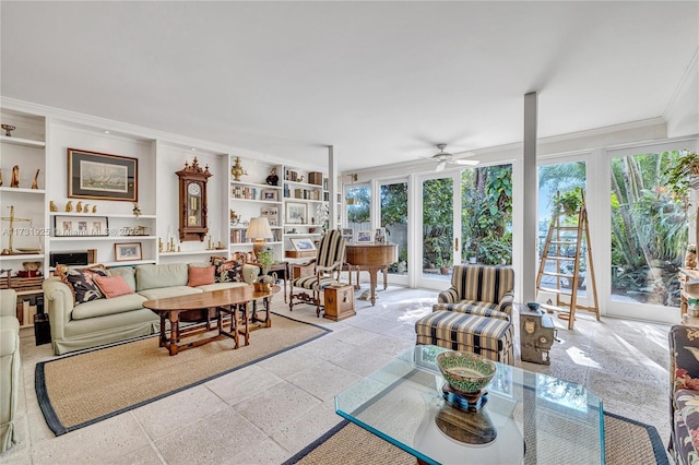 living room featuring crown molding, ceiling fan, and built in shelves