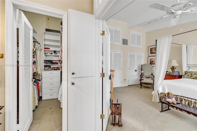 carpeted bedroom with ceiling fan and beam ceiling