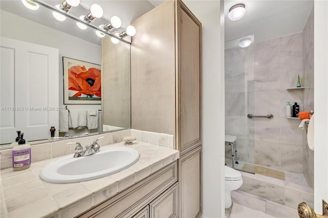 bathroom featuring tiled shower, vanity, and toilet