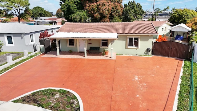 view of front of property featuring a residential view, a gate, a tiled roof, and stucco siding